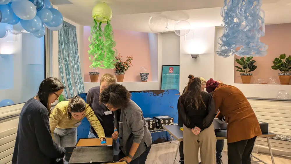 Des participants penchés sur des coffrets à cadenas pendant un escape game