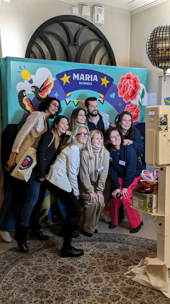 Un groupe de participants pose en riant devant le photobooth